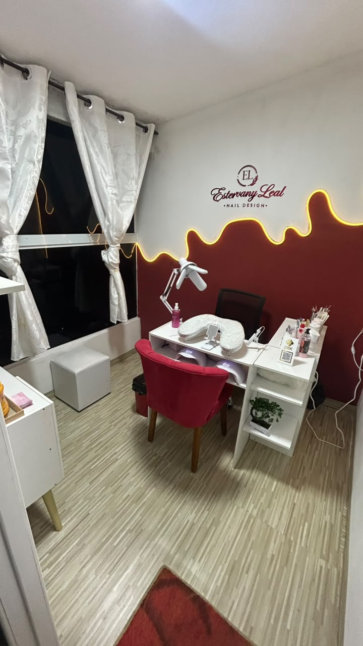 Visão geral do studio Estervany Leal com parede vinho, logo e LED